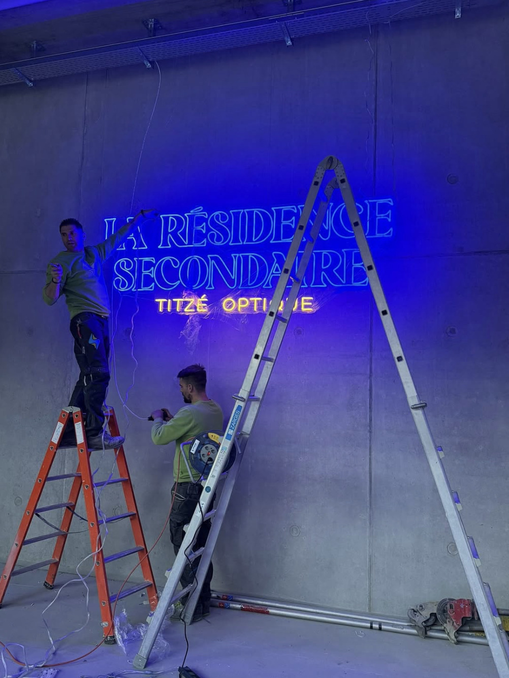 Deux techniciens LED Studio installant une enseigne néon