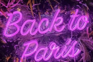 Néon Flex « Back to Paris » en rose, gros plan sur le mur végétal